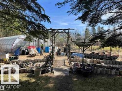 Expansive outdoor area featuring a large greenhouse structure and an adjacent shed - 
