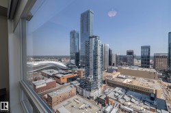 Expansive urban landscape featuring modern high-rise architecture and a large stadium structure - 