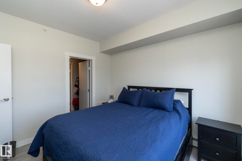 Bedroom featuring light gray walls, light wood-finish flooring, white baseboards, and a semi-flush mount ceiling light - #2402 10410 102 Av Nw, Edmonton, AB - Indoor Photo Showing Bedroom