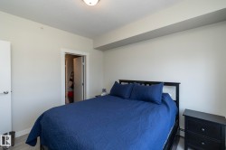 Bedroom featuring light gray walls, light wood-finish flooring, white baseboards, and a semi-flush mount ceiling light - 