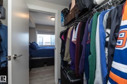 Walk-in closet featuring wire shelving, hanging rods, light gray walls, and wood-finish flooring - 