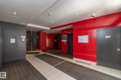 Contemporary common area featuring red accent walls, recessed lighting, and a blend of dark and light tiled flooring - 