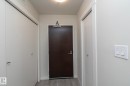 Entryway with light grey wood-finish flooring, a dark wood-finish door, and integrated overhead lighting - #2402 10410 102 Av Nw, Edmonton, AB  - Indoor Photo Showing Other Room 