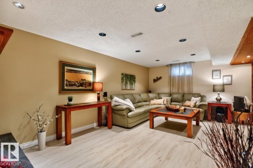 Recessed lighting illuminating a spacious living area with wood-finish flooring - 4631 113A Street Nw, Edmonton, AB - Indoor