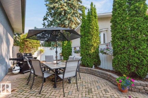 Herringbone brick paver patio featuring a retaining wall - 4631 113A Street Nw, Edmonton, AB - Outdoor With Deck Patio Veranda With Exterior