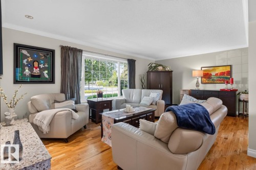 Bright living area featuring wood-finish flooring, a large window, recessed lighting, and crown molding - 4631 113A Street Nw, Edmonton, AB - Indoor Photo Showing Living Room