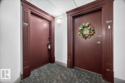 Entryway featuring two solid core doors with decorative trim, wall sconce lighting, and textured carpet flooring - 