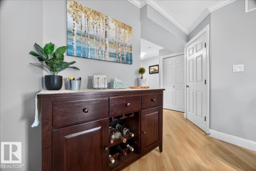 Hallway with light wood-finish flooring, light gray wall paint, and white crown molding - #306 13111 140 Av Nw, Edmonton, AB - Indoor Photo Showing Other Room
