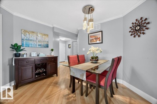 Dining area featuring light wood-finish flooring, light grey walls, and white crown molding - #306 13111 140 Av Nw, Edmonton, AB - Indoor Photo Showing Dining Room