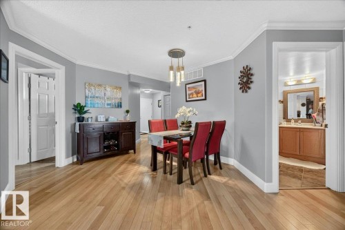 Hardwood-style flooring extends throughout this interior space - #306 13111 140 Av Nw, Edmonton, AB - Indoor Photo Showing Dining Room