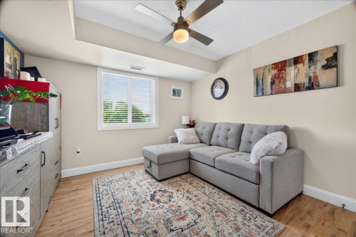 Recessed ceiling with integrated lighting and a ceiling fan - #306 13111 140 Av Nw, Edmonton, AB - Indoor Photo Showing Living Room