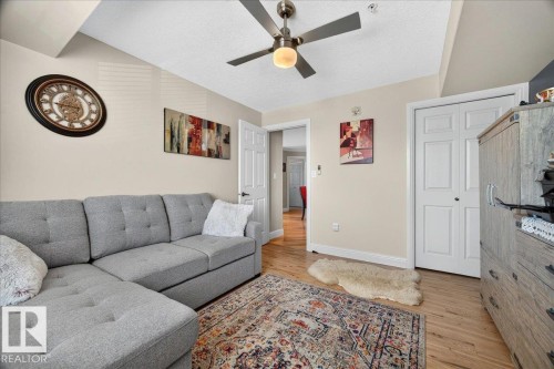 Hardwood-finish flooring featuring a ceiling fan with integrated lighting - #306 13111 140 Av Nw, Edmonton, AB - Indoor Photo Showing Living Room