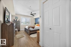 Bedroom featuring wood-finish flooring, a ceiling fan, and a window with horizontal blinds - 