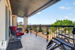 Spacious balcony featuring a textured concrete floor, black metal railings, and a dark paneled ceiling - 