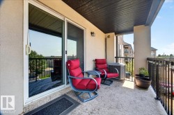 Private balcony featuring concrete flooring, a black railing, and exterior lighting fixtures - 