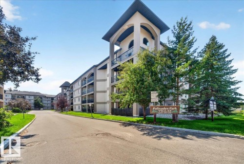 Multi-story residential building featuring a prominent arched entrance tower - #306 13111 140 Av Nw, Edmonton, AB - Outdoor With Balcony