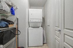 Dedicated laundry area featuring a stacked washer and dryer unit, wire shelving storage, and paneled doors - 