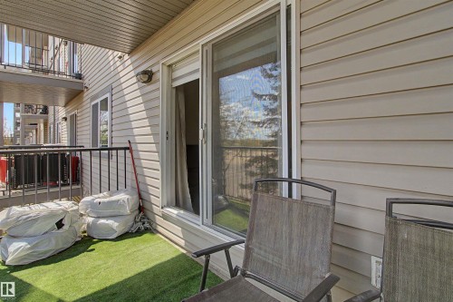 Balcony area featuring artificial turf flooring and a sliding glass door - #204 309 Clareview Station Dr Nw, Edmonton, AB - Outdoor With Balcony With Exterior