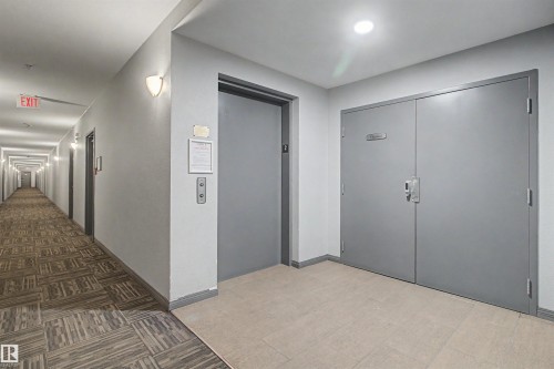 Building corridor featuring elevator access and double entry doors - #204 309 Clareview Station Dr Nw, Edmonton, AB - Indoor Photo Showing Other Room