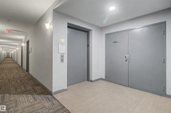 Building corridor featuring elevator access and double entry doors - 