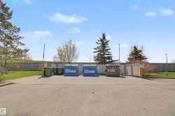 Paved lot with perimeter fencing and mature trees - 