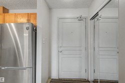 Entryway featuring a panel door with an overhead door closer and adjacent mirrored closet doors - 