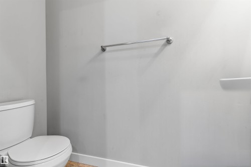 Bathroom featuring a white toilet, chrome towel bar, and light-colored flooring - #62 675 Watt Bv Sw, Edmonton, AB - Indoor Photo Showing Bathroom