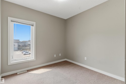 Bright room with light gray walls, white trim, and neutral carpet flooring - #62 675 Watt Bv Sw, Edmonton, AB - Indoor Photo Showing Other Room