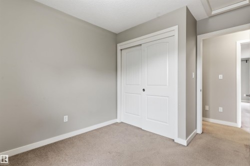 Neutral-toned walls complement a substantial carpeted floor - #62 675 Watt Bv Sw, Edmonton, AB - Indoor Photo Showing Other Room