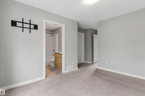 Neutral wall color with plush carpeting, featuring a built-in television mount - #62 675 Watt Bv Sw, Edmonton, AB - Indoor Photo Showing Other Room