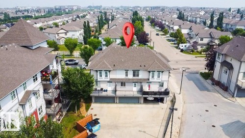 Multi-level townhome featuring a neutral stucco exterior, individual attached garages, and private balconies - #62 675 Watt Bv Sw, Edmonton, AB - Outdoor