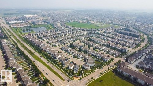 Aerial perspective showcasing a residential community with multiple detached homes and townhomes - #62 675 Watt Bv Sw, Edmonton, AB - Outdoor With View