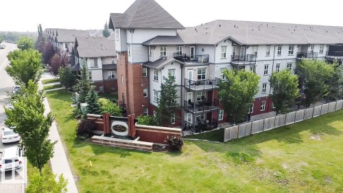 Multi-story building featuring brick and siding facade, private balconies, and a gabled roofline - #62 675 Watt Bv Sw, Edmonton, AB - Outdoor With Balcony