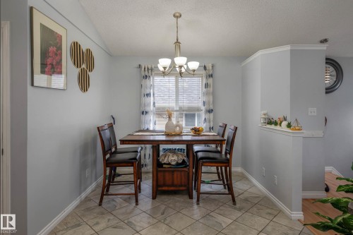 Dining area with tile flooring and a multi-light chandelier - 9113 166 Avenue Nw, Edmonton, AB - Indoor Photo Showing Dining Room