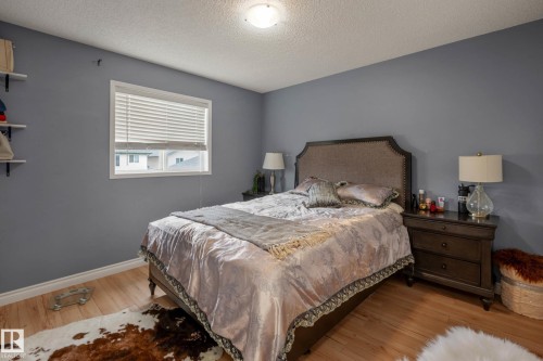Bedroom with wood-finish flooring, a white-trimmed window, and a built-in shelf unit - 9113 166 Avenue Nw, Edmonton, AB - Indoor Photo Showing Bedroom