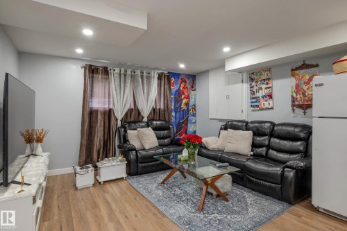 Recessed lighting illuminates this living space featuring wood-finish flooring and light gray walls - 9113 166 Avenue Nw, Edmonton, AB - Indoor