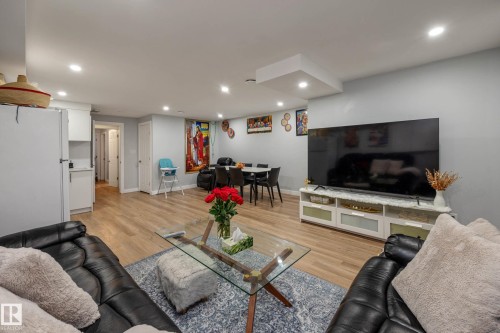 Open-concept living area with wood-finish flooring, recessed lighting, and light gray walls - 9113 166 Avenue Nw, Edmonton, AB - Indoor