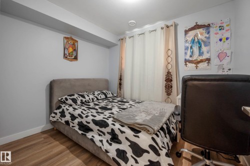Bedroom featuring wood-finish flooring, light gray walls, white baseboards, and ceiling-mounted lighting - 9113 166 Avenue Nw, Edmonton, AB - Indoor Photo Showing Bedroom