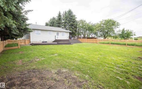 Expansive backyard with a generous lawn and a newly installed wooden privacy fence - 5116 51 Avenue, Pickardville, AB - Outdoor