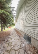 Stone pathway bordering the property, leading past mature trees - 