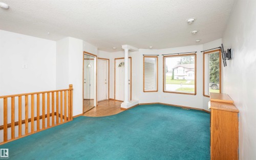 Carpeted living area with a bay window, recessed lighting, and wood-finish trim - 5116 51 Avenue, Pickardville, AB - Indoor Photo Showing Other Room