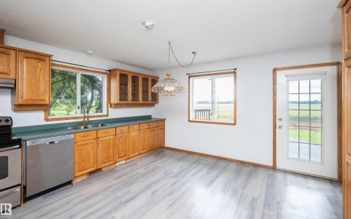 Kitchen space featuring wood-finish cabinetry, stainless steel appliances, and a double basin sink - 5116 51 Avenue, Pickardville, AB - Indoor Photo Showing Kitchen With Double Sink