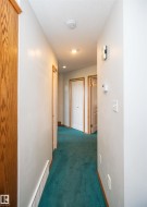 Hallway featuring recessed lighting, a built-in smoke detector, and wood-finish door frames - 