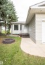Exterior featuring light-colored horizontal siding, a bay window with white trim, and mature evergreen trees - 5116 51 Avenue, Pickardville, AB  - Outdoor 