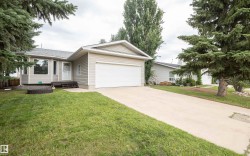 Exterior featuring beige siding, an attached garage with a white door, and a concrete driveway - 