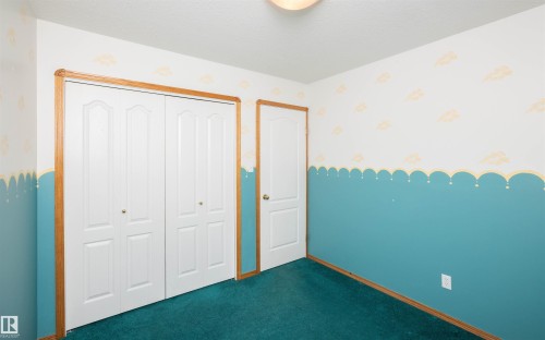 Room featuring bi-fold panel closet doors with brass-finish knobs and wood trim - 5116 51 Avenue, Pickardville, AB - Indoor Photo Showing Other Room