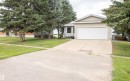 Exterior featuring a two-car garage with a white door, light-toned siding, a concrete driveway, and mature evergreen trees - 5116 51 Avenue, Pickardville, AB  - Outdoor 