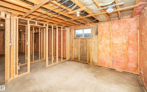 Unfinished basement area featuring exposed wood framing, concrete flooring, and partial insulation - 5116 51 Avenue, Pickardville, AB - Indoor Photo Showing Basement