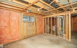 Unfinished basement offering exposed wood framing, ceiling joists, and a concrete floor - 