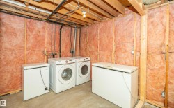 Unfinished basement utility area featuring exposed wood framing, ceiling joists, and wall insulation - 